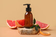 © Pixel-Shot - Bottle of cosmetic product, pieces of grapefruit and stone on beige background, closeup