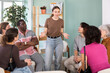 © JackF - Confident young woman standing and speaking to a diverse group during circle discussion