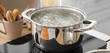 © Pixel-Shot - Stainless steel pot with boiling water on stove in kitchen, closeup