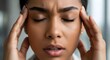 © Andres Mejia - Close-up of a Stressed Young Woman Suffering from Headache or Migraine, Hands on Temples with Eyes Closed