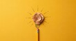 © Asma - Creative Light Bulb Idea and Innovation Concept with Yellow Pencil Eraser and Spiraled Wood Shavings on Bright Yellow Background