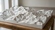 © Huzaifa Creatives - Detailed white topographical relief model showcasing intricate mountain ridges and valleys on a handcrafted rectangular plaster base