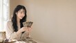 © AiPhoto - 窓辺の光の中でタロットカードを眺め微笑む女性と余白