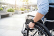 © Meow Creations - Disabled young man confidently gripping wheelchair wheel outdoors