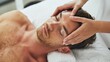 © Olya Pilipchik  - Male client enjoying a relaxing facial massage at a modern spa, receiving professional skincare treatment for wellness and rejuvenation, focusing on head and face care