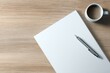 © sogap - overhead shot of clean workspace with pen on blank paper and coffee cup on wooden desk
