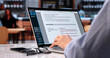 © Andrey Popov - Young Woman Writing Resume On Laptop