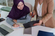 © Pichsakul - Muslim businesswoman hijab consulting coworker office meeting discussing project strategy tablet laptop notebook professional workplace collaboration teamwork