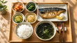© May - Minimalist Korean lunch set with grilled mackerel, seaweed soup, and kimchi on wooden tray with copy space