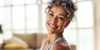 © Yevheniiya - Close-up portrait of a smiling middle-aged woman with graying curly hair, looking healthy and happy
