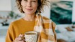 © Pinklife - A serene woman holding a warm drink and a cozy plaid blanket, radiating a sense of contentment and relaxation in a beautifully designed interior space filled with natural light.