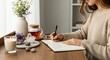 © Tan - Woman writing in a journal after meditation, surrounded by calming elements like tea and crystals, promoting wellness and reflection.