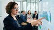 © Justlight - Focused view of a digital strategist pointing at detailed campaign analytics on a large monitor showcasing clear data charts with the client team sitting out of focus.
