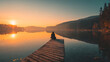 © Facundo - A person sitting on a dock by a lake at sunset, gazing at the calm water.