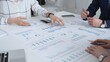 © volha_r - Business team in a conference room reviewing financial reports, charts and graphs across the table, collaborating on strategy, investment planning and growth initiatives