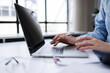 © groviapoto - Businesswoman hands on a laptop using pen and trackpad, typing and navigating for data entry, online communication and digital workplace tasks in a bright office setting