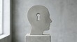 © MSTMAYA - Concrete human head sculpture with a keyhole symbol standing on a pedestal in a room