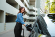 © Parichat - Young businesswoman preparing for journey with luggage and car
