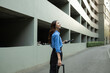© Parichat - Professional woman traveling urban street holding tablet and luggage