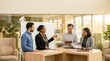 © Saraswati - Diverse business team collaborating and brainstorming around a high table with whiteboard in bright contemporary office