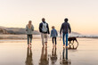 © Cavan Images - Dad and children walking dogs on New Zealand beach