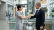 © MST - Male professional and female doctor shaking hands in modern hospital
