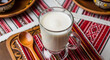 © Adis N. Tyas - Ryazhenka, baked fermented milk beverage akin to a yogurt or kefir popular from the Eastern Europe region, especially Ukraine and Belarus served in a glass with spoon against Ukrainian cafe background