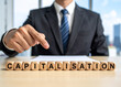 © magele-picture - Capitalisation - Geschäftsmann zeigt auf den Text 'Capitalisation'