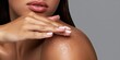 © NovaVision - Woman's hand gently applying body scrub to her smooth shoulder for skincare