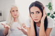 © deagreez - Daughter covering her ears during argument with upset mother at home, family conflict and generational tension causing emotional stress
