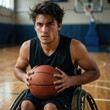 © Alex Pios - Focused portrait of young wheelchair basketball player holding ball on court, symbol of resilience, health, and sports motivation