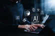 © Supatman - AI co-worker automation and digital workflow concept. Professional using laptop with icons for artificial intelligence, cloud systems, chatbot, coding, data tools, global network, smart productivity