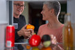 © Jelena - Mature couple choosing fresh vegetables from refrigerator