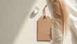 © miss irine - Minimalist flat lay features natural elements like large feather, clear crystal. Craft paper tag hangs with twine, casting soft shadows. Neutral color palette ideal for wellness spiritual content.