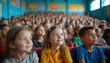 © miss irine - Children sit in auditorium watching a performance. Many young students fill rows looking forward with happy attentive faces. Some kids look curious and engaged in school event.