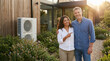 © Elena - Middle-aged couple smiling and posing outside their modern home