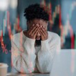 © Andrii Zastrozhnov - Man distressed covering face at desk with market graph overlay