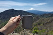 © Tsubasa005 - 山頂で富士山を眺めながらコーヒーを飲む。登山やハイキングでの休憩、リラックス、ソロキャンプ、アウトドアライフスタイルのイメージ。