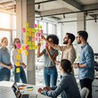 © juanpost - Group of multiethnic business people brainstorming together in modern office.