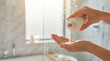 © Illustratorstock - Close-up of a woman pouring rich liquid shampoo into her hand in a bright modern luxury bathroom. Beauty, daily body care, and hygiene concept with copy space.