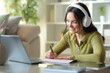 © Antonioguillem - Happy teenage student e-learning and taking notes