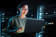 © Konstantin Yuganov - Confident IT Specialist Working on Laptop in Modern Server Room