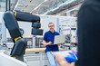 © Westend61 - Engineer with laptop in modern factory with industrial robot during meeting