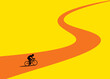 © Westend61 - Cyclist silhouette on a winding road illustrating journey and effort