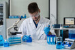 © NINENII - Lab work, Doctor holds a test tube takes the test from a test tube in analysis, blood, DNA, test tube stand.