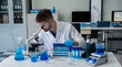 © NINENII - Lab work, Doctor holds a test tube takes the test from a test tube in analysis, blood, DNA, test tube stand.