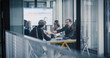 © Gorodenkoff - Business Team Meets in a Glass Conference Room to Review Financial Dashboards, Share Printed Reports, Discuss Performance Trends, and Agree on Strategy, Using Laptops, Charts, and Digital Tools