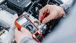 © Viktoriia - Mechanic using multimeter for car electrical diagnostics in workshop