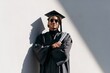 © Lubos Chlubny - Young graduate student celebrating academic success holding diploma