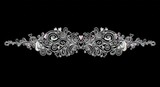Symmetrical silver filigree ornament with swirling floral scrolls, intricate vine patterns, and small pastel heart accents on a black background